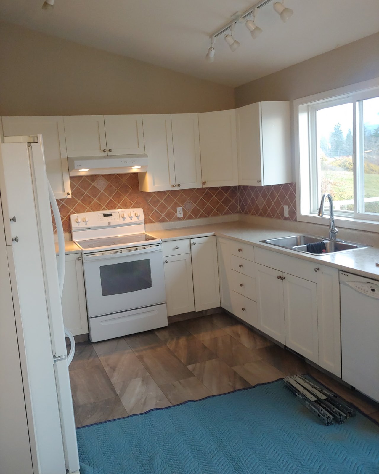 Kelowna kitchen before refacing — painted white shaker doors