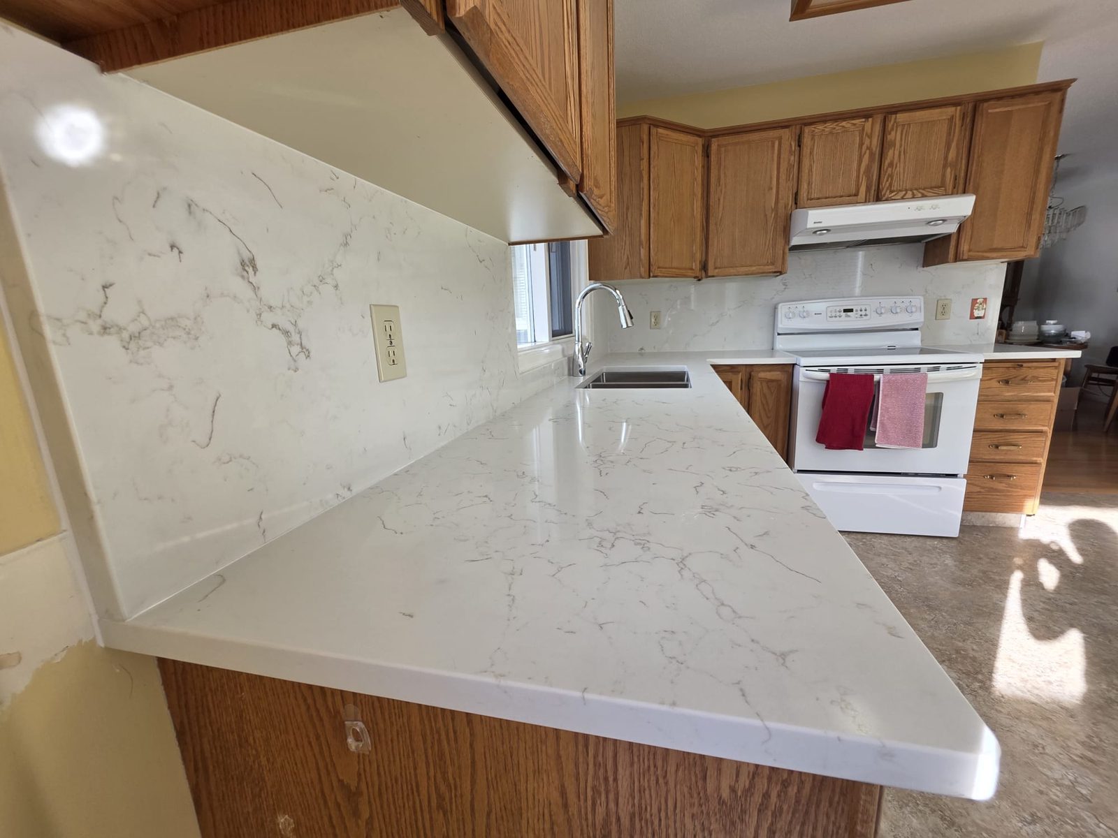 Kelowna kitchen counter after — marble-look quartz with full backsplash