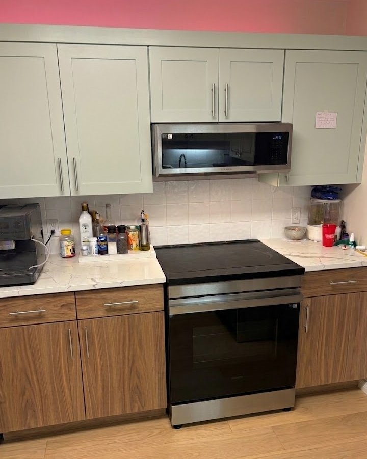 Kelowna kitchen after refacing — two-tone sage green uppers and walnut lowers